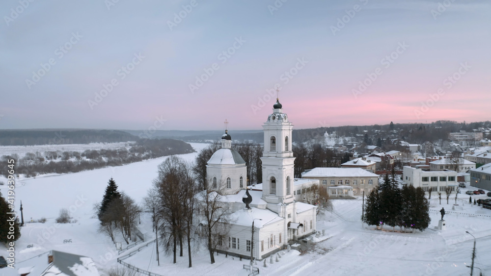 Aerial view of russian winter countryside Tarusa. Flying over village, Orthodox church, River, Snow