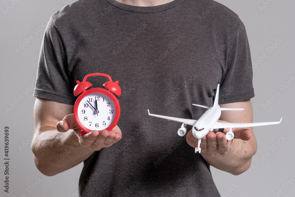 Manual red alarm clock and miniature aircraft. in hands of man. Flight