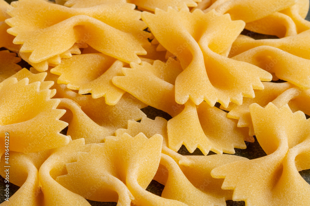 Raw yellow pasta farfalle close up. Raw yellow pasta farfalle close up.