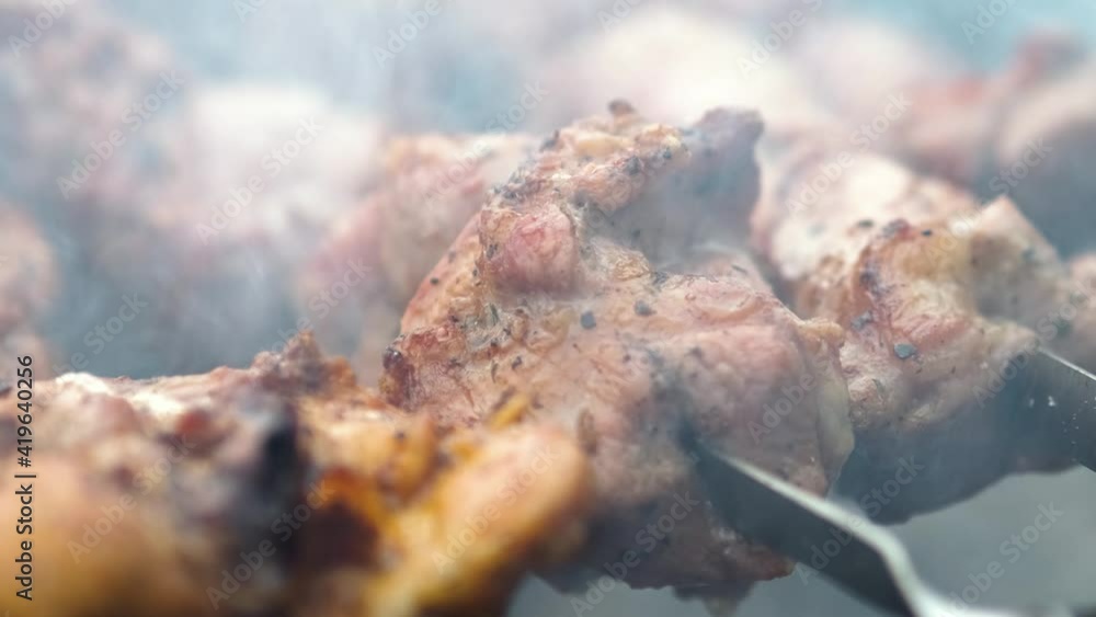 Shashlik or shish kebab preparing on barbecue grill over hot charcoal. Grilled pieces of pork meat on metal skewers. Shashlik or shish kebab preparing on barbecue grill over hot charcoal. Grilled pieces of pork meat on metal skewers.