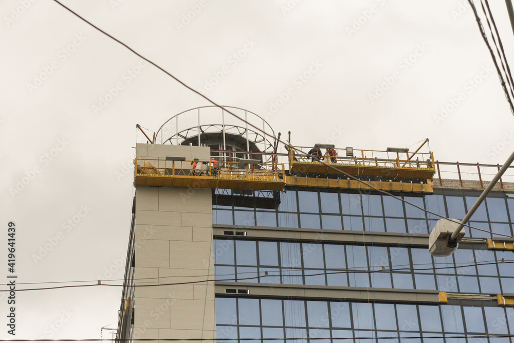 building under construction with workers in a construction winch building under construction with workers in a construction winch