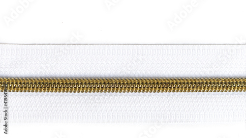 White zipper with gold teeth isolated on white background. Clothing fastener.	