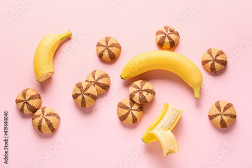 Composition with tasty cookies and bananas on color background
