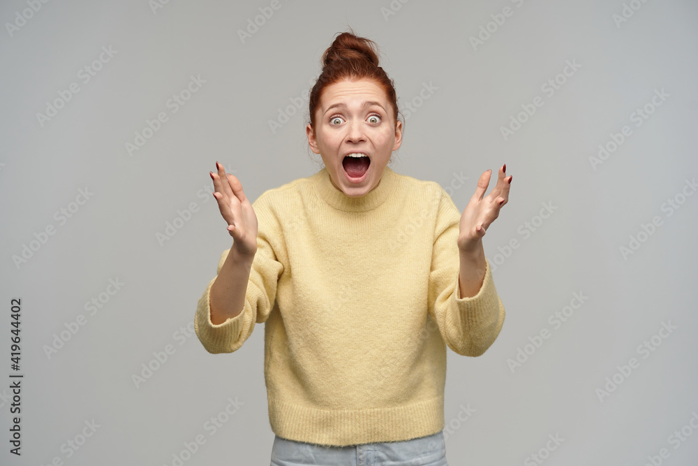 Horrified looking woman with ginger hair gathered in a bun. Wearing ...