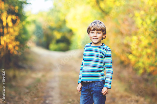 Portrait of little cool kid boy in forest. Happy healthy child having fun on warm sunny day early autumn. Family, nature, love and active leisure. © Irina Schmidt