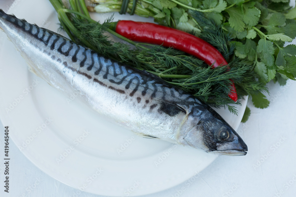 Fresh raw mackerel Scomber on a plate with red pepper, dill and cilantro. Fresh raw mackerel Scomber on a plate with red pepper, dill and cilantro.