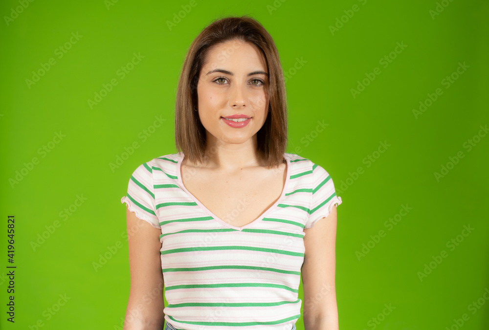 Portrait of young beautiful woman wearing casual t-shirt smiling looking at camera over green background. Portrait of young beautiful woman wearing casual t-shirt smiling looking at camera over green background.