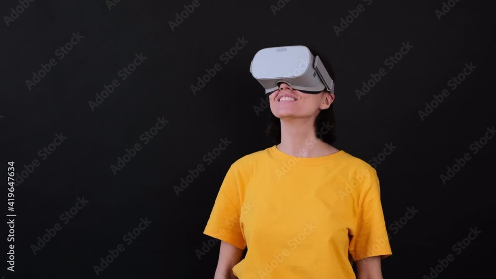 Woman wearing vr glasses and happy look around on black background Woman wearing vr glasses and happy look around on black background