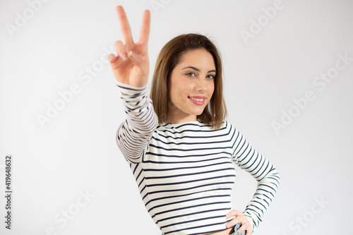Young pretty woman isolated showing victory sign and smiling broadly. © Danko