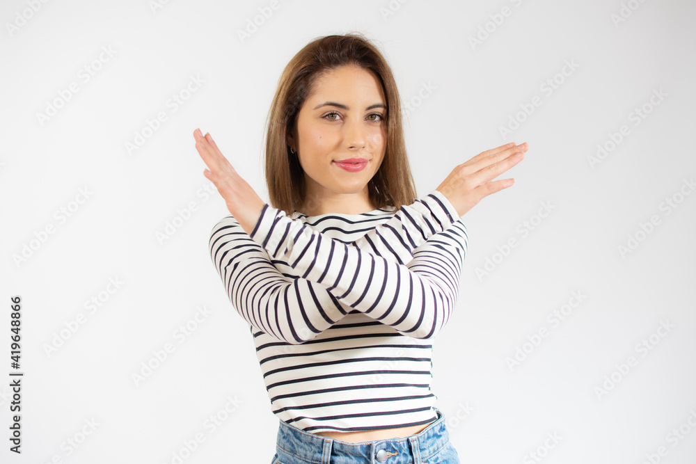 Young woman wearing striped t-shirt with rejection expression crossing arms and palms doing negative sign. Young woman wearing striped t-shirt with rejection expression crossing arms and palms doing negative sign.
