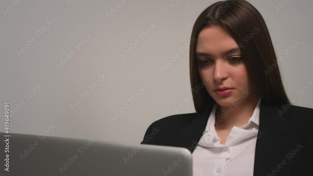 Portrait of pretty caucasian woman working on laptop. Serious woman freelancer working on laptop looking at the monitor at home office. Remote work freelancer at home workplace Portrait of pretty caucasian woman working on laptop. Serious woman freelancer working on laptop looking at the monitor at home office. Remote work freelancer at home workplace