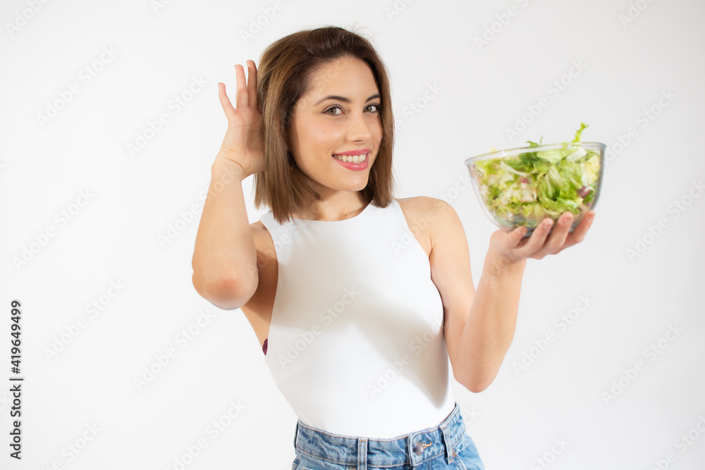 Young woman showing a bowl of salad isolated over white background Young woman showing a bowl of salad isolated over white background