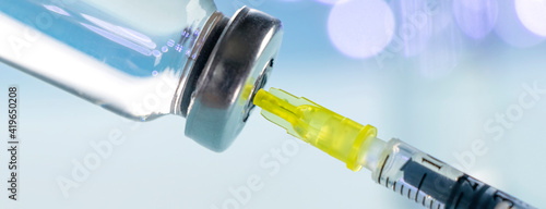 Vaccine vial dose flu shot drug needle syringe on blue background. Medical concept vaccination hypodermic injection treatment disease care hospital prevention immunization illness disease baby child.