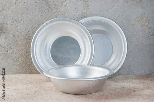Metal bowls on a concrete background.