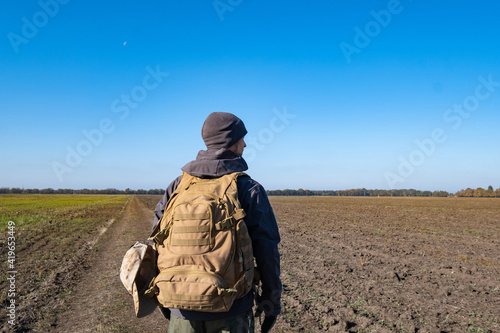 Male traveler with tactical and militari equipment walk alone in sunny day