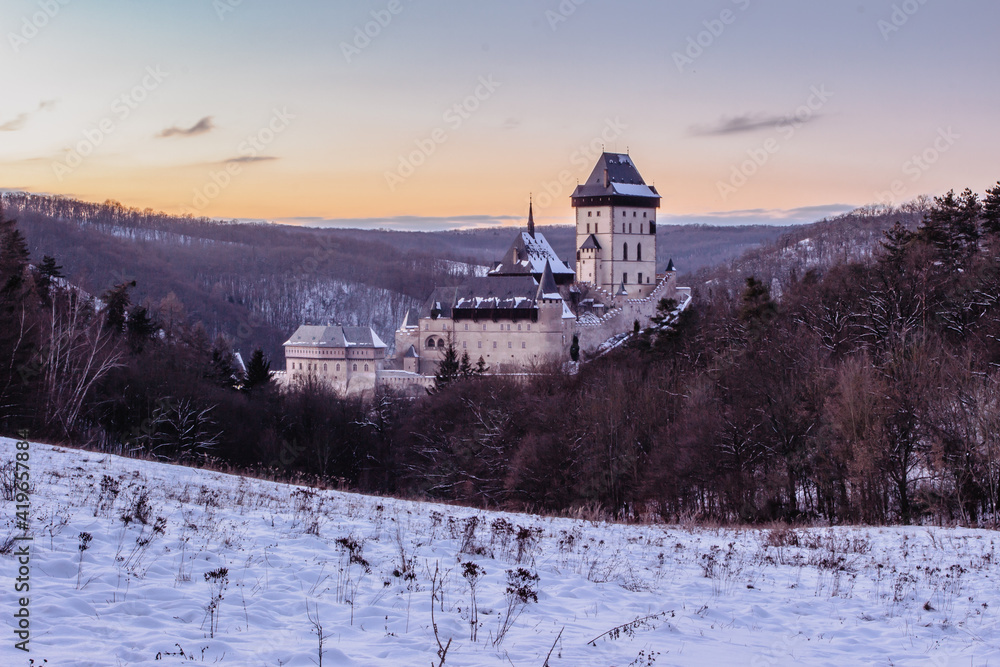 Beautiful gothic Royal Karlstejn Castle in winter with snow,Czech Republic.Founded by Charles IV.There are Czech crown jewels, holy relics, and royal treasures.Most popular Czech castle at sunset