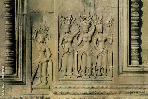 Stone bas reliefs depicting scenes of rural life and historical events on the walls of Angkor Wat, Siem Reap, Indochina photo