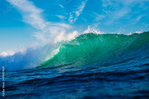Turquoise waves in ocean. Breaking wave with light