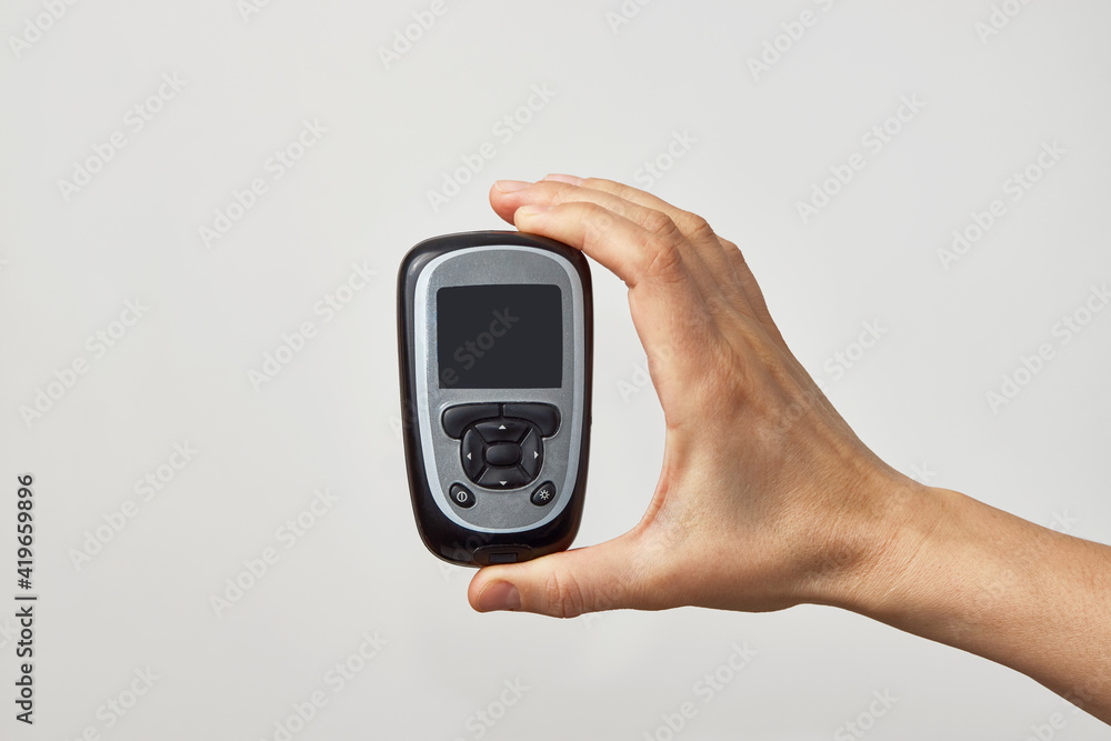 Hand holding glucometer with blood sugar test result. Hand holding glucometer with blood sugar test result.