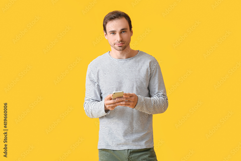 Handsome young man with mobile phone on color background Handsome young man with mobile phone on color background