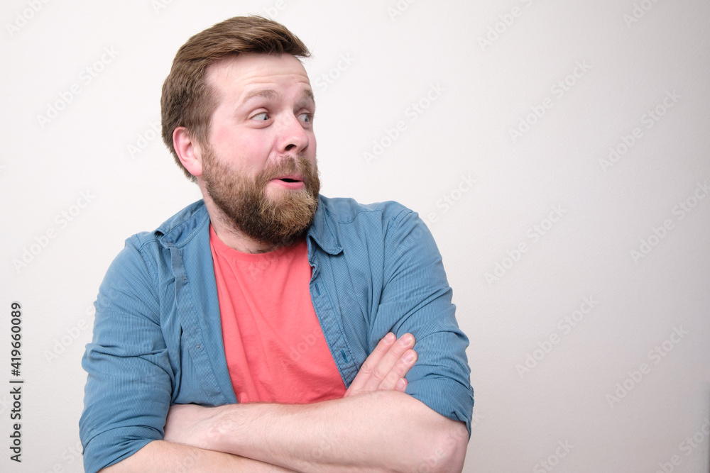 Funny, charming man surprised looking to the side. Copy space. White background. Funny, charming man surprised looking to the side. Copy space. White background.