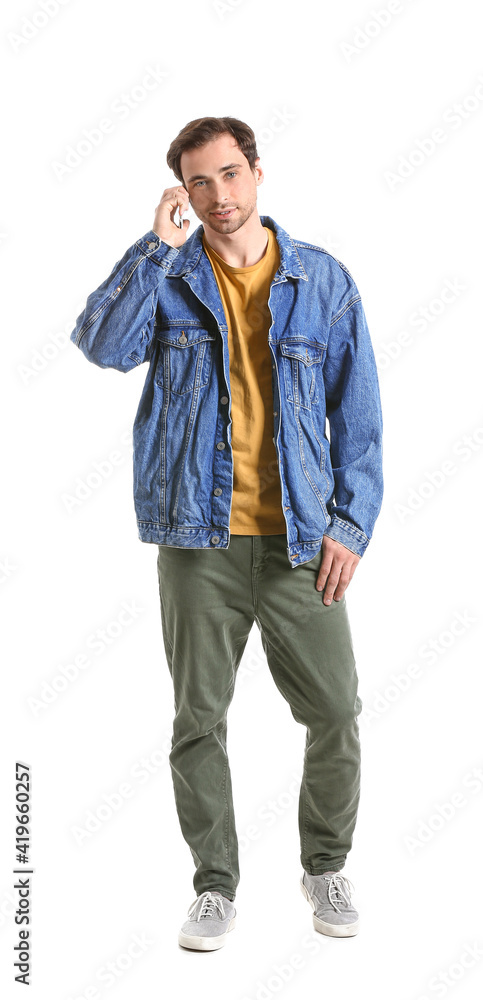 Fototapeta premium Handsome young man talking by mobile phone on white background