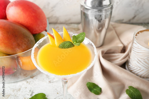 Glass of mango margarita on light background