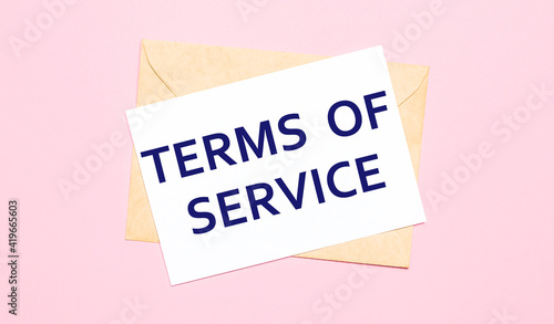 On a light pink background - a craft envelope. It has a white sheet of paper that says TERMS OF SERVICE.