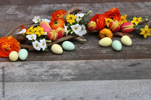 Osterhintergrund: Blumen und Ostereier auf altem Holz