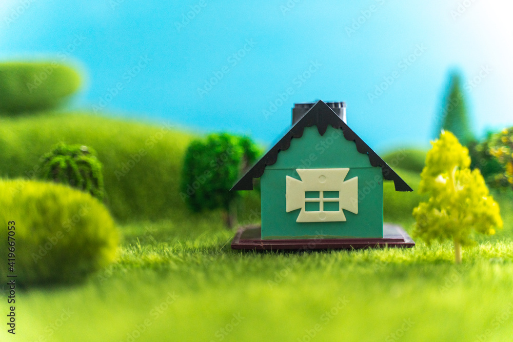 A toy house on green grass in fictional world A toy house on green grass in fictional world