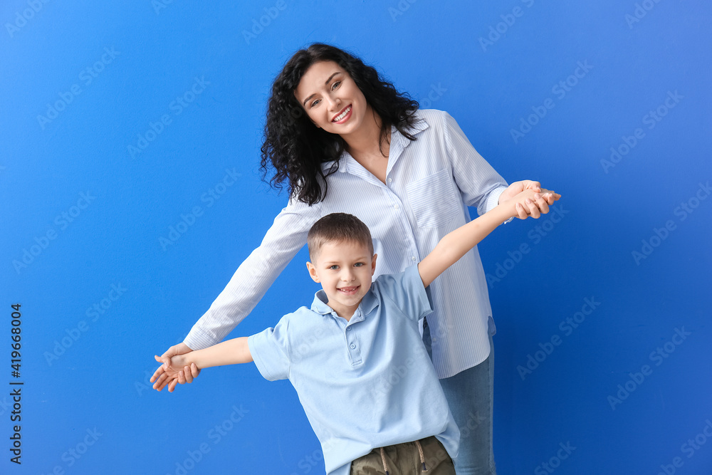 Happy woman and her little son on color background Happy woman and her little son on color background