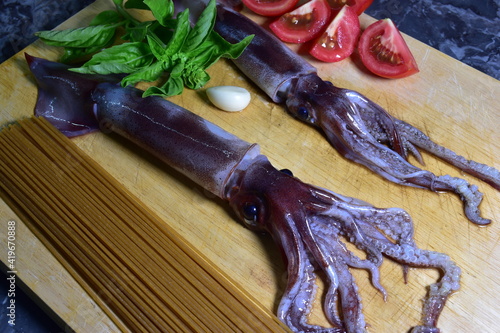 Obraz na płótnie Preparazione di spaghetti tipo chitarra con totani freschi, pomodoro e basilico. Sicilia, Palermo. Cucina tipica w salonie