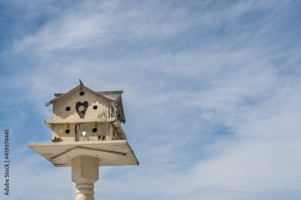 Large two-story birdhouse against blue sky. Large two-story birdhouse against blue sky.