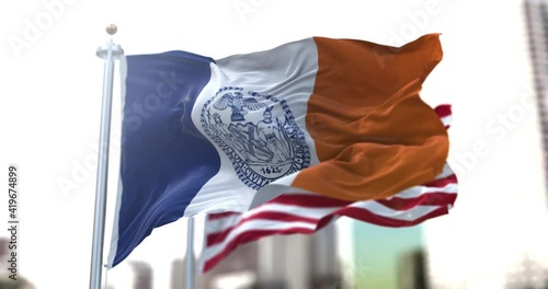 the official flag of New York City flapping along with the American Stars and Stripes national flag in the background