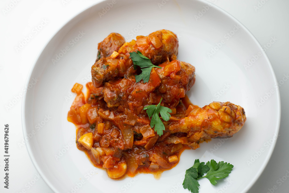 Plato de pollo casero, salsa de tomate y especias Plato de pollo casero, salsa de tomate y especias