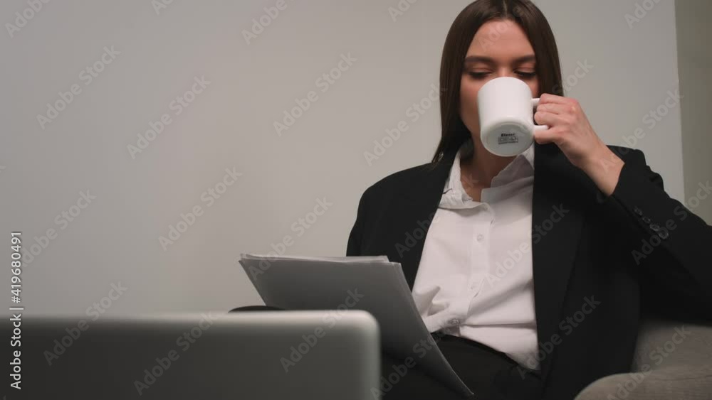 Caucasian pretty businesswoman working with papers documents at home or office. Woman drinking coffee at home office. Caucasian pretty businesswoman working with papers documents at home or office. Woman drinking coffee at home office.