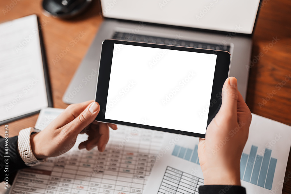 Male hands holding tablet with blank background at workplace. Businessman working at desk with documents Male hands holding tablet with blank background at workplace. Businessman working at desk with documents