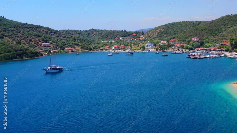 Aerial panoramic view to luxury yacht club in Mediterranean sea bay with sailing ship boats in clear blue water near white sand beach in Greece, Europe Aerial panoramic view to luxury yacht club in Mediterranean sea bay with sailing ship boats in clear blue water near white sand beach in Greece, Europe