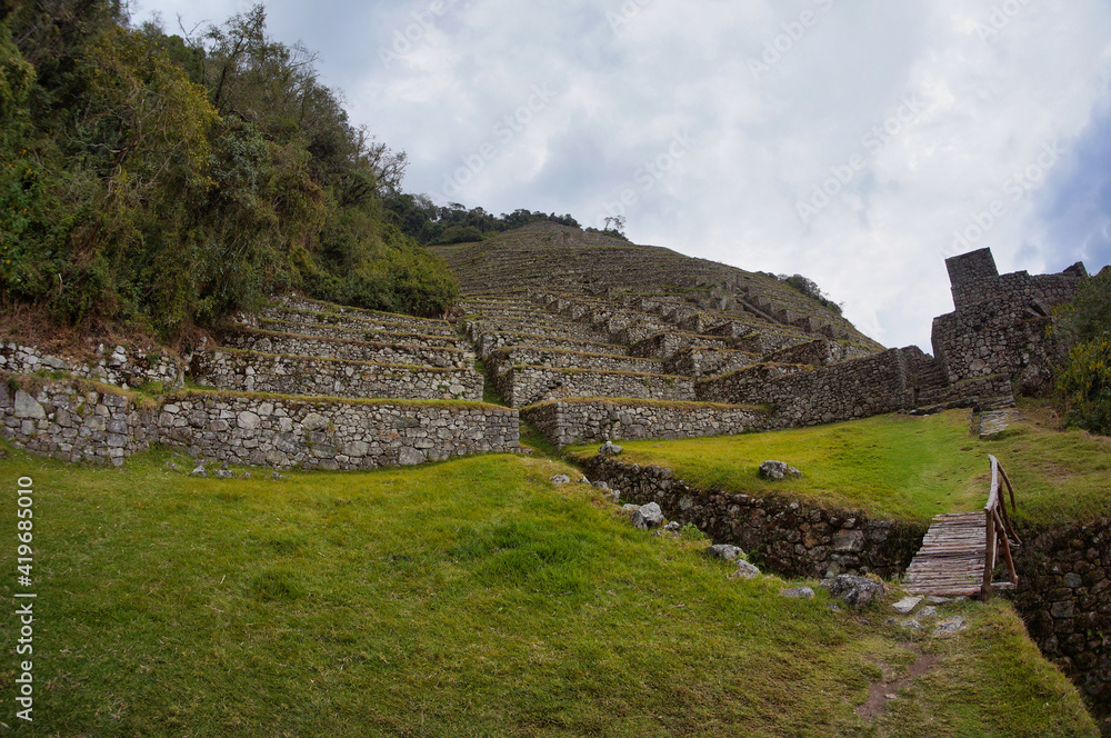 Bridge over stream in front of ancient Inca ruins in Peru 