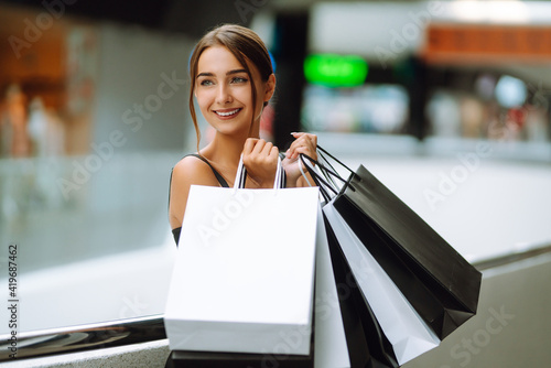 Young woman after shopping walking in the mall. The joy of consumption, purchases, black friday, discounts, sale concept.