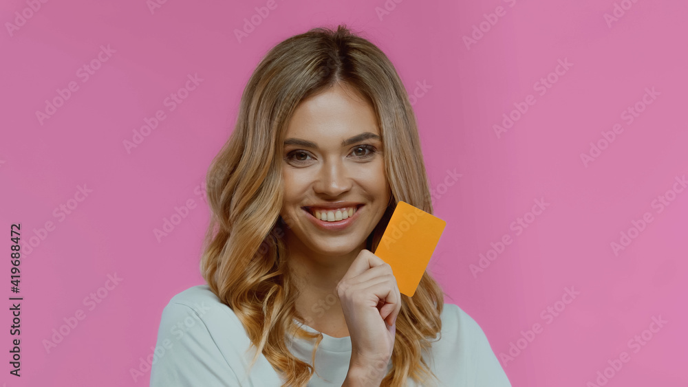 happy young woman holding credit card isolated on pink happy young woman holding credit card isolated on pink