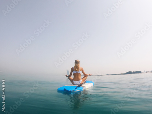 Woman meditating on the paddle board © sashapritchard