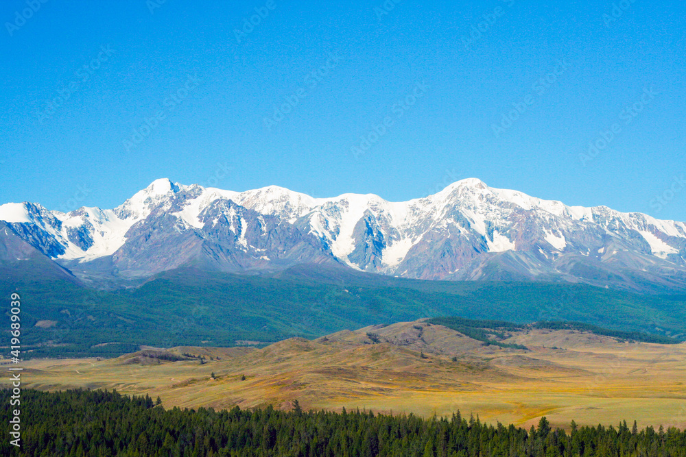 Beautiful mountain landscape. Snow-capped mountains, steppe and conifers. Russia, Altai mountains, Chuysky ridge