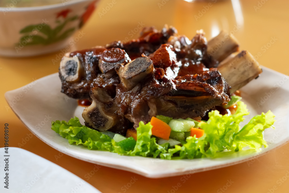grilled beef ribs on white plate in the table grilled beef ribs on white plate in the table