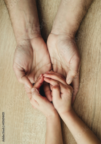 children's hands in the hands of adults