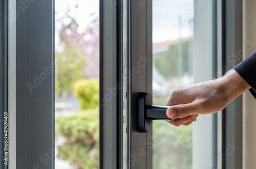 Aluminum window frame detail. Male hand opens the metal door closeup view. Free Download Aluminum window frame detail. Male hand opens the metal door closeup view. - GFXLoad