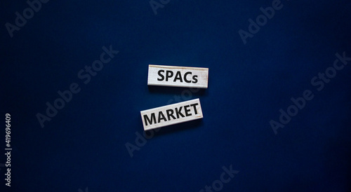 SPACs market symbol. Wooden blocks with words 'SPACs, special purpose acquisition companies market' on beautiful black background, copy space. Business and SPACs market concept. photo