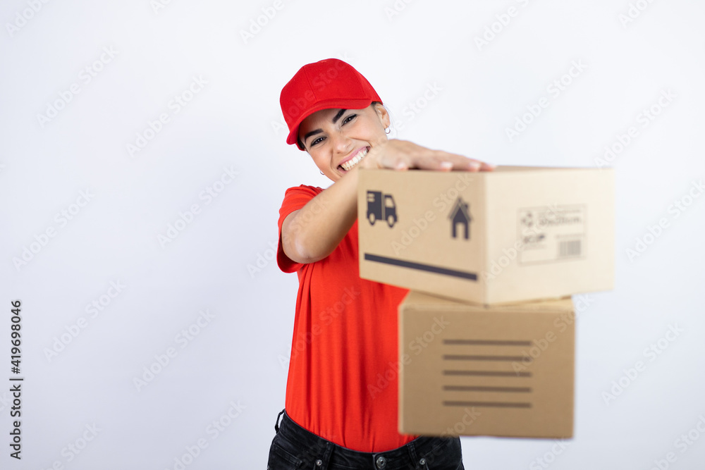 Young beautiful woman wearing courier uniform holding delivery packages with a happy face standing and smiling with a confident smile showing teeth Young beautiful woman wearing courier uniform holding delivery packages with a happy face standing and smiling with a confident smile showing teeth