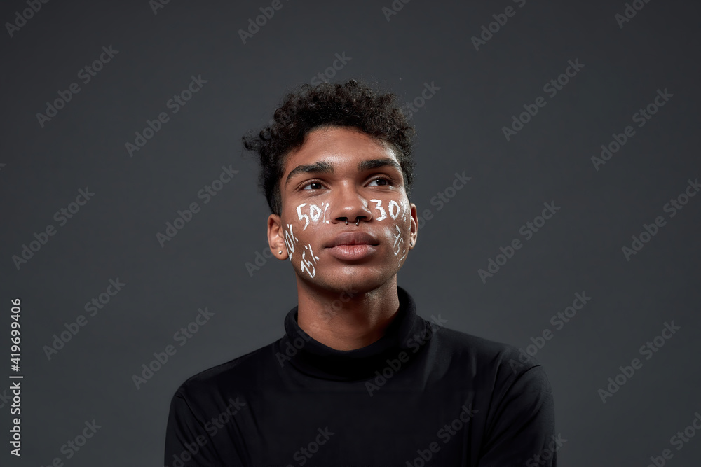 Obraz premium Portrait of young guy with lettering on his face