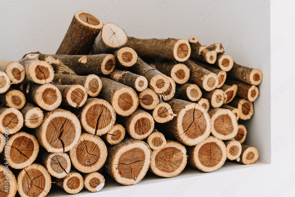 Chopped stacked firewood on a shelf in white wall. Chopped stacked firewood on a shelf in white wall.